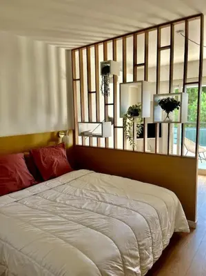 Un ou plusieurs lits dans un hébergement de l'établissement Studio calme avec vue sur un grand Pin parasol