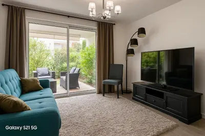 Télévision ou salle de divertissement dans l'établissement Palm beach apartment with swimming pool in a residence