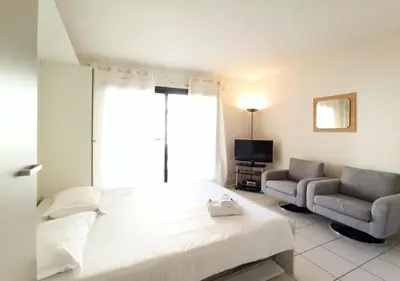 Un ou plusieurs lits dans un hébergement de l'établissement Viva Riviera - Studio Jardin Florian