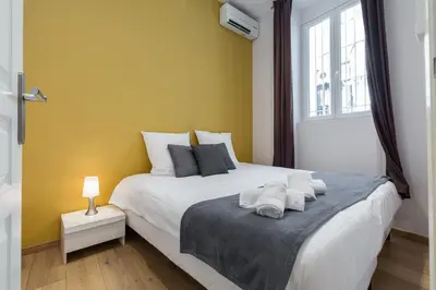 Un ou plusieurs lits dans un hébergement de l'établissement Florella Marceau Apartment