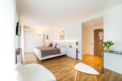 Un ou plusieurs lits dans un hébergement de l'établissement Hôtel Hélios